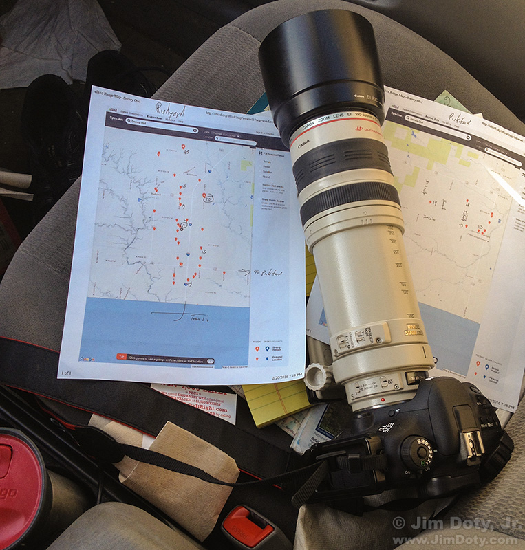 Camera with lens, printed eBird maps, and Michigan Atlas and Gazetteer..